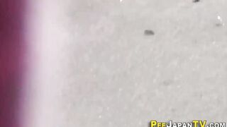 Watch this kinky Japanese babe get drenched in golden showers while peeing in public - 1 image